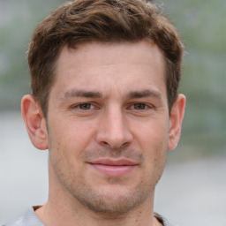 Joyful white young-adult male with short  brown hair and grey eyes