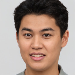 Joyful asian young-adult male with short  brown hair and brown eyes