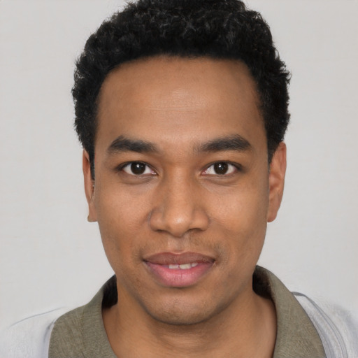 Joyful black young-adult male with short  black hair and brown eyes