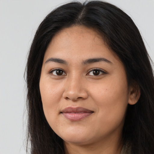 Joyful latino young-adult female with long  brown hair and brown eyes