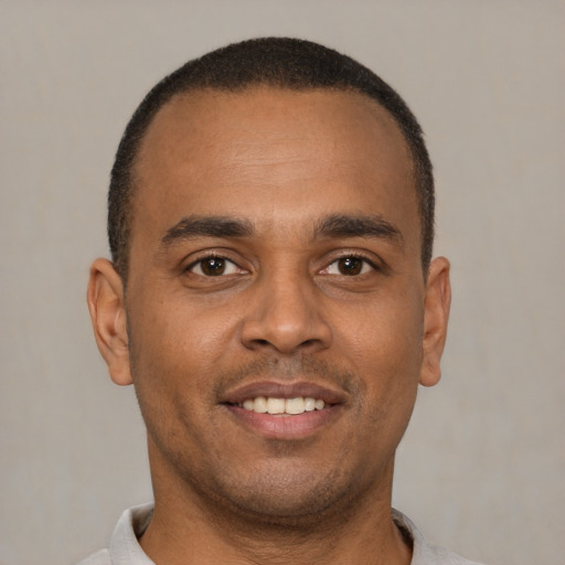 Joyful latino young-adult male with short  brown hair and brown eyes