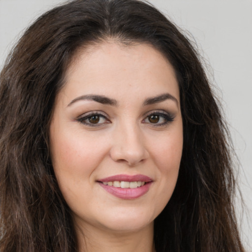 Joyful white young-adult female with long  brown hair and brown eyes