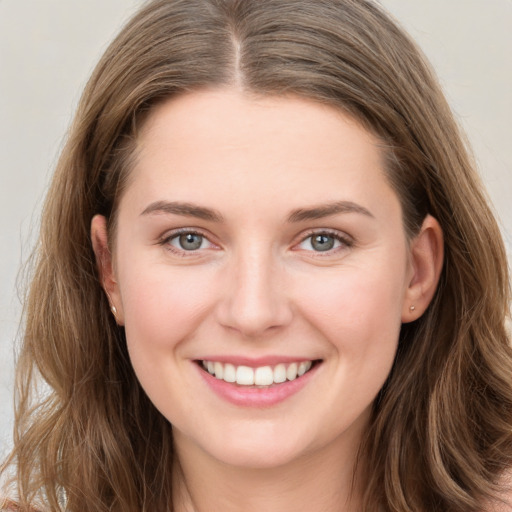 Joyful white young-adult female with long  brown hair and grey eyes