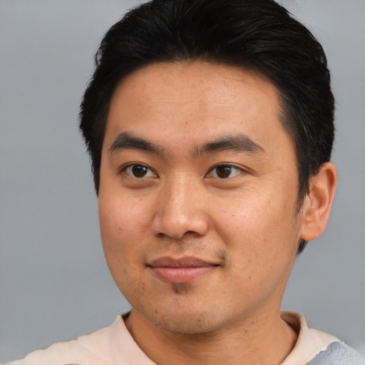 Joyful asian young-adult male with short  brown hair and brown eyes