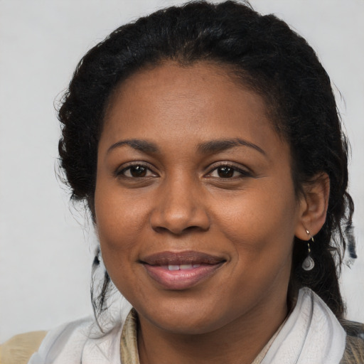 Joyful black young-adult female with long  brown hair and brown eyes
