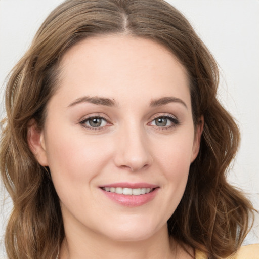 Joyful white young-adult female with long  brown hair and green eyes