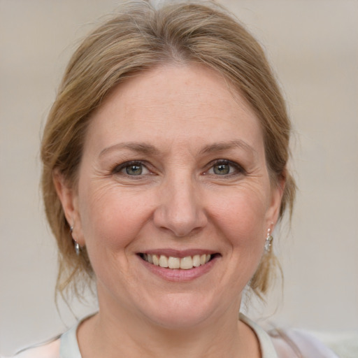 Joyful white adult female with medium  brown hair and blue eyes