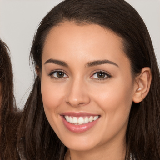 Joyful white young-adult female with long  brown hair and brown eyes