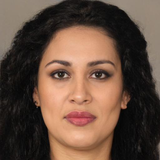 Joyful latino young-adult female with long  black hair and brown eyes