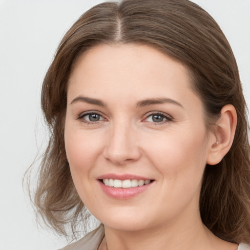 Joyful white young-adult female with long  brown hair and grey eyes