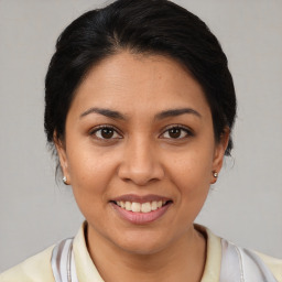 Joyful latino young-adult female with medium  brown hair and brown eyes