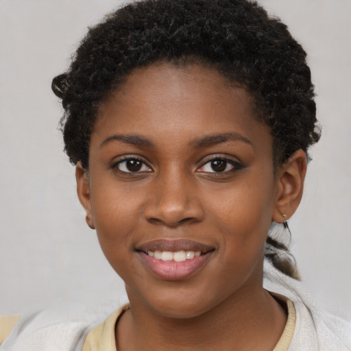 Joyful black young-adult female with short  brown hair and brown eyes