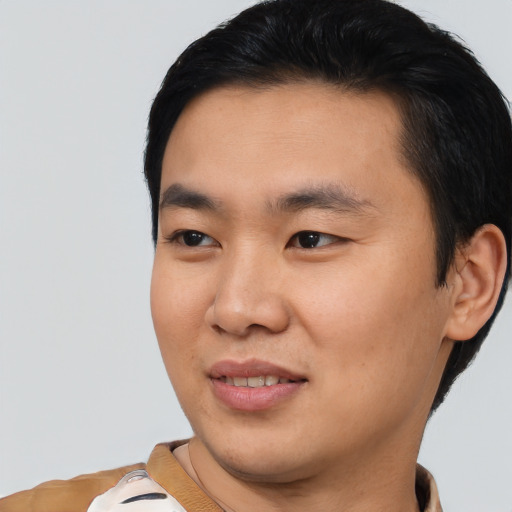 Joyful asian young-adult male with short  black hair and brown eyes