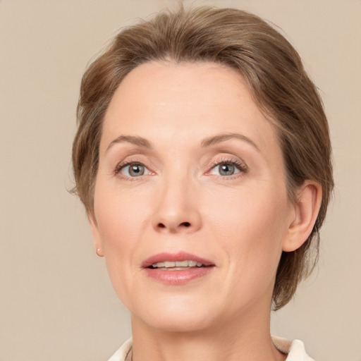 Joyful white adult female with medium  brown hair and grey eyes