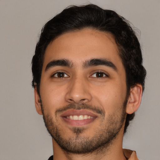 Joyful latino young-adult male with short  brown hair and brown eyes