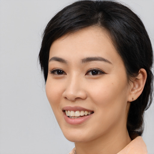 Joyful asian young-adult female with medium  black hair and brown eyes
