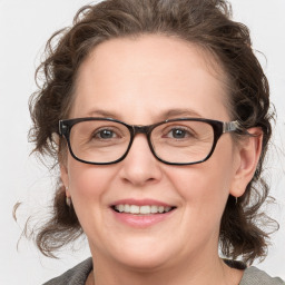 Joyful white adult female with medium  brown hair and blue eyes