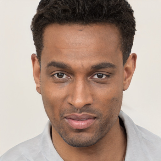 Joyful black young-adult male with short  brown hair and brown eyes