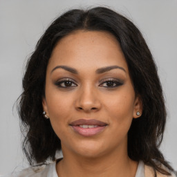 Joyful latino young-adult female with medium  brown hair and brown eyes