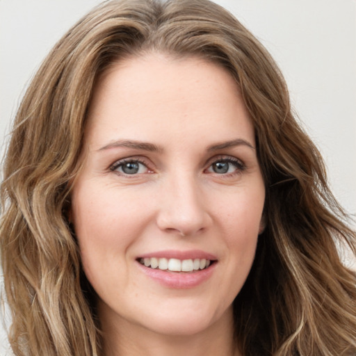 Joyful white young-adult female with long  brown hair and green eyes