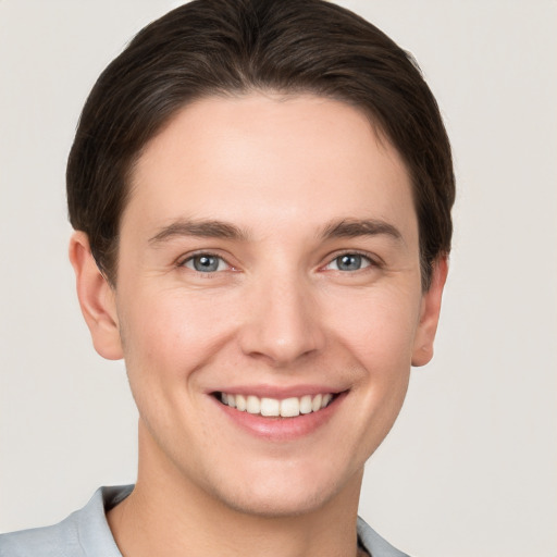 Joyful white young-adult male with short  brown hair and grey eyes