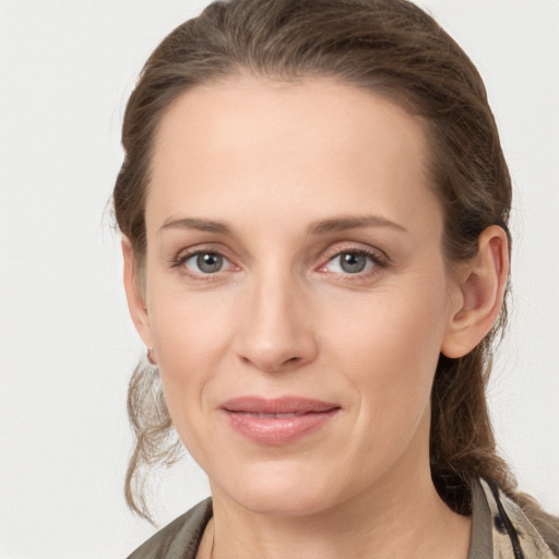 Joyful white young-adult female with medium  brown hair and grey eyes