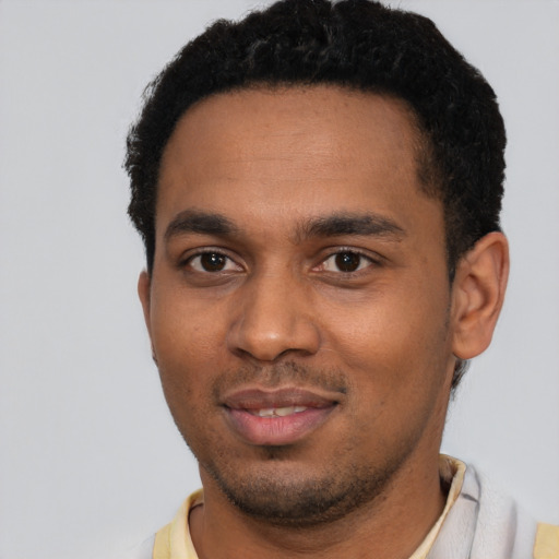 Joyful black young-adult male with short  black hair and brown eyes