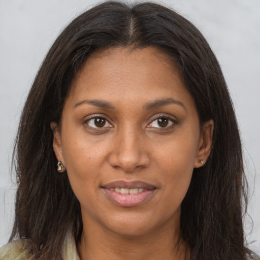 Joyful black young-adult female with long  brown hair and brown eyes