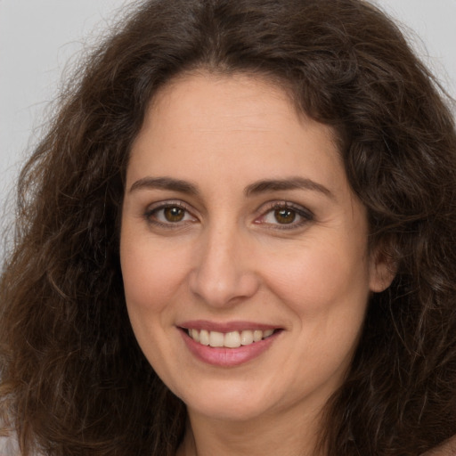 Joyful white adult female with long  brown hair and brown eyes