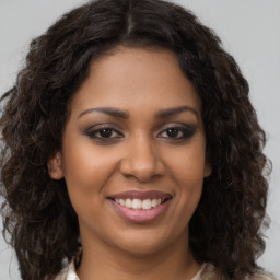 Joyful black young-adult female with long  brown hair and brown eyes