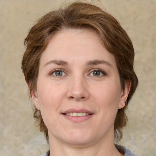 Joyful white adult female with medium  brown hair and green eyes