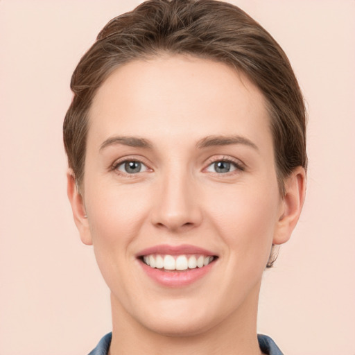 Joyful white young-adult female with short  brown hair and grey eyes