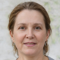 Joyful white adult female with medium  brown hair and grey eyes