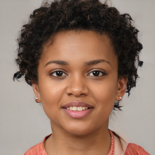 Joyful black child female with short  brown hair and brown eyes