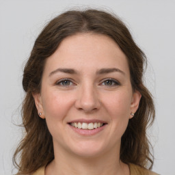 Joyful white young-adult female with medium  brown hair and grey eyes