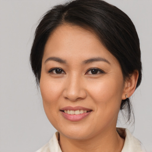 Joyful asian young-adult female with medium  brown hair and brown eyes