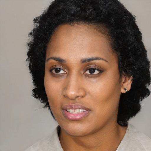 Joyful black young-adult female with medium  black hair and brown eyes