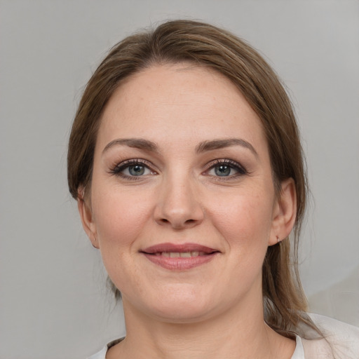 Joyful white young-adult female with medium  brown hair and grey eyes