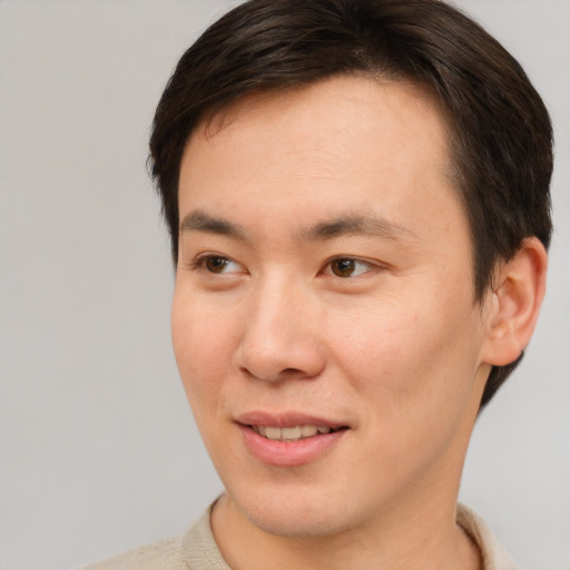 Joyful asian young-adult male with short  brown hair and brown eyes