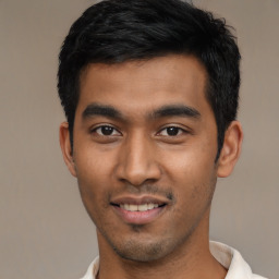 Joyful latino young-adult male with short  black hair and brown eyes