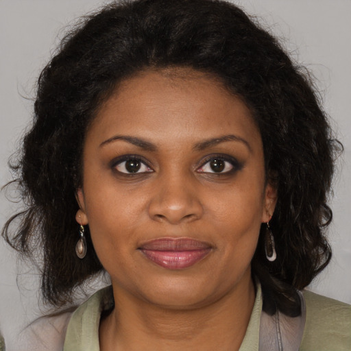 Joyful black young-adult female with long  brown hair and brown eyes