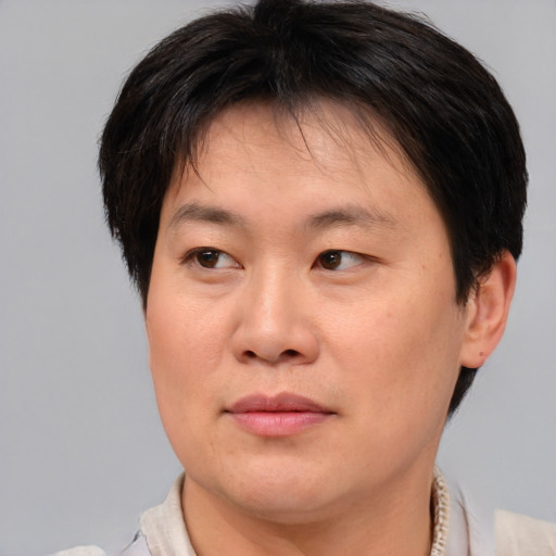 Joyful asian adult female with short  brown hair and brown eyes