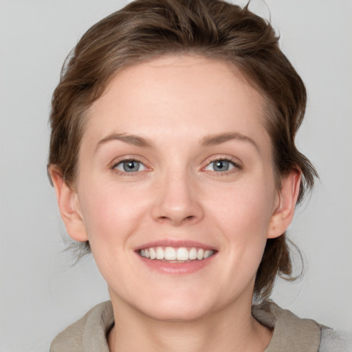 Joyful white young-adult female with medium  brown hair and blue eyes