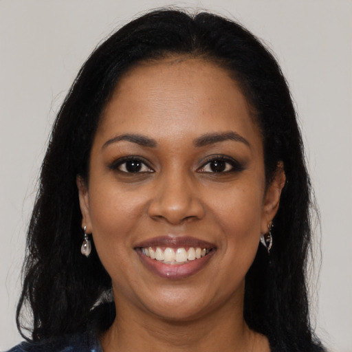 Joyful black young-adult female with long  black hair and brown eyes