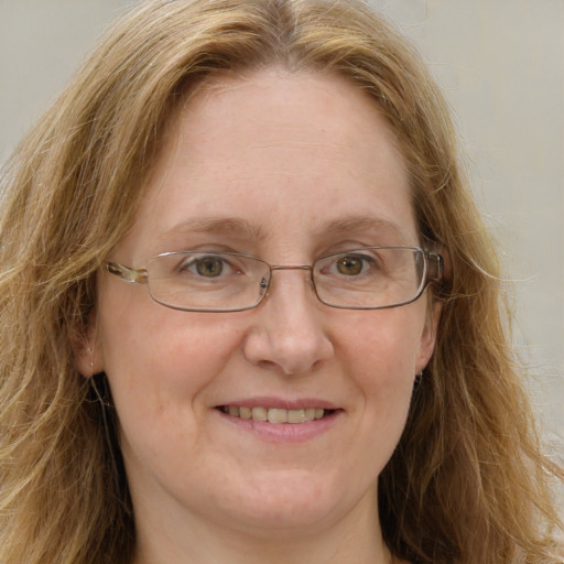 Joyful white adult female with long  brown hair and blue eyes