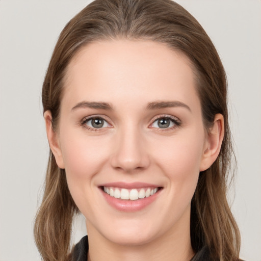 Joyful white young-adult female with long  brown hair and grey eyes