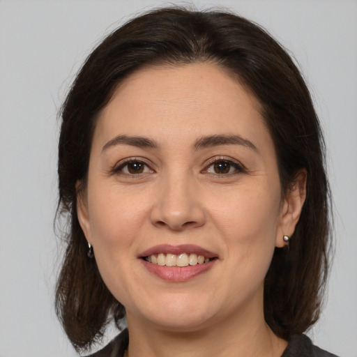 Joyful white young-adult female with medium  brown hair and brown eyes