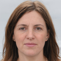 Joyful white adult female with long  brown hair and grey eyes