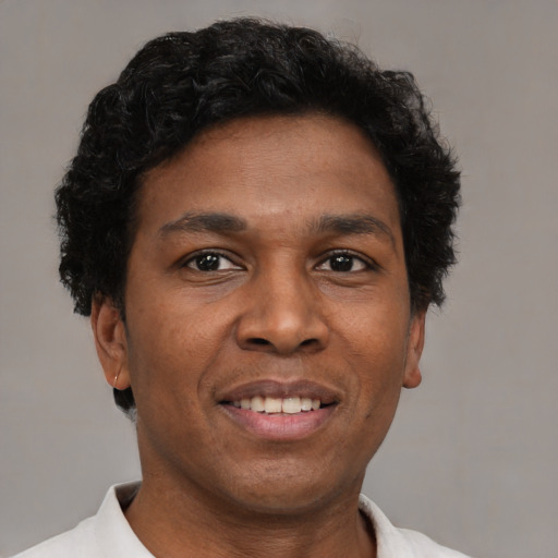 Joyful latino adult male with short  brown hair and brown eyes