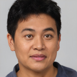 Joyful asian young-adult male with short  brown hair and brown eyes